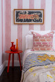 A bright and playful bedroom featuring the Brome Stripe wallpaper in a custom hot pink colourway, bringing bold energy to the interior. Photography by Antonia Blunt.